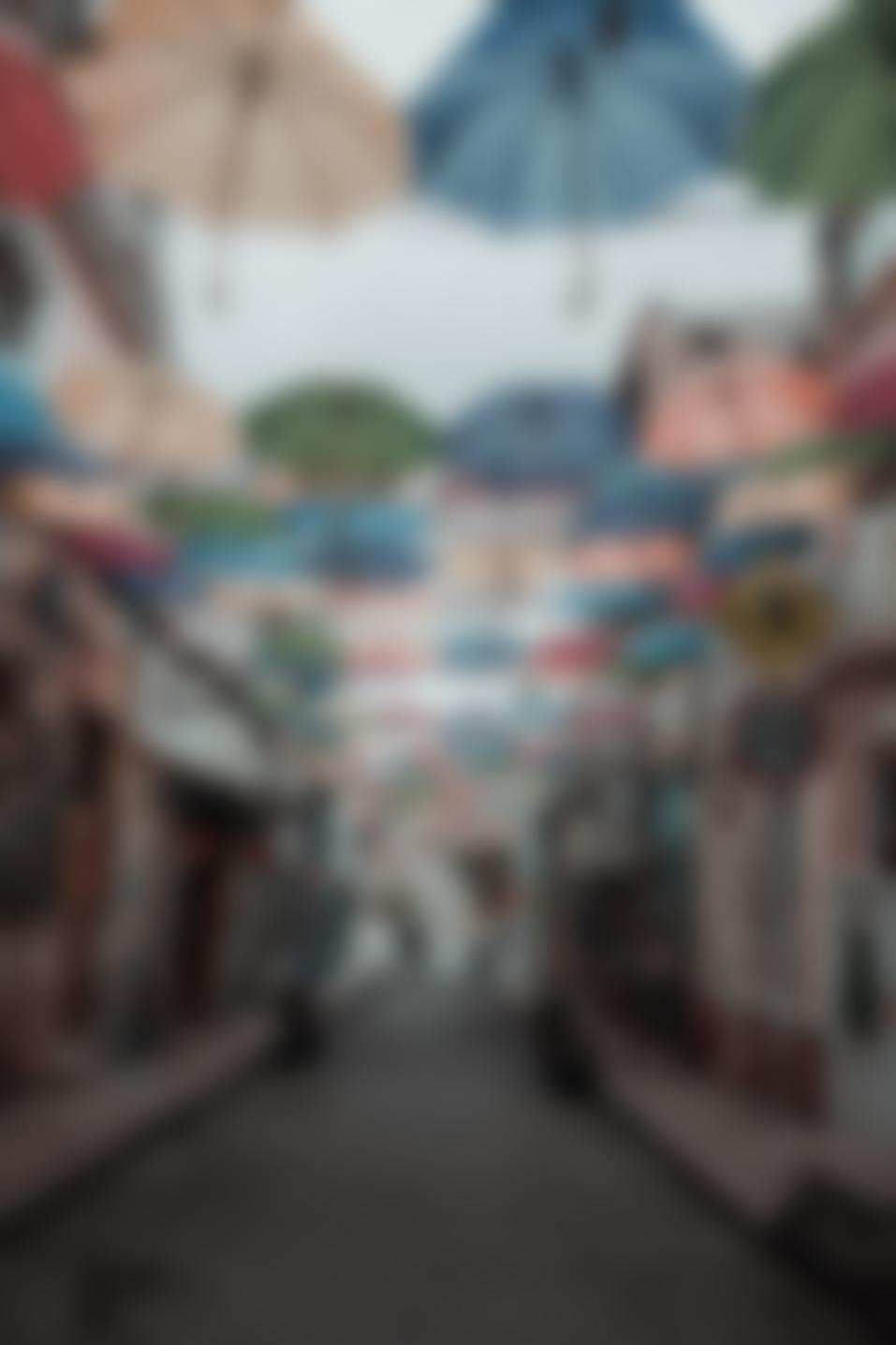 A blurred, quiet view of umbrellas — the STML Services umbrella sheltering its boring, dependable products